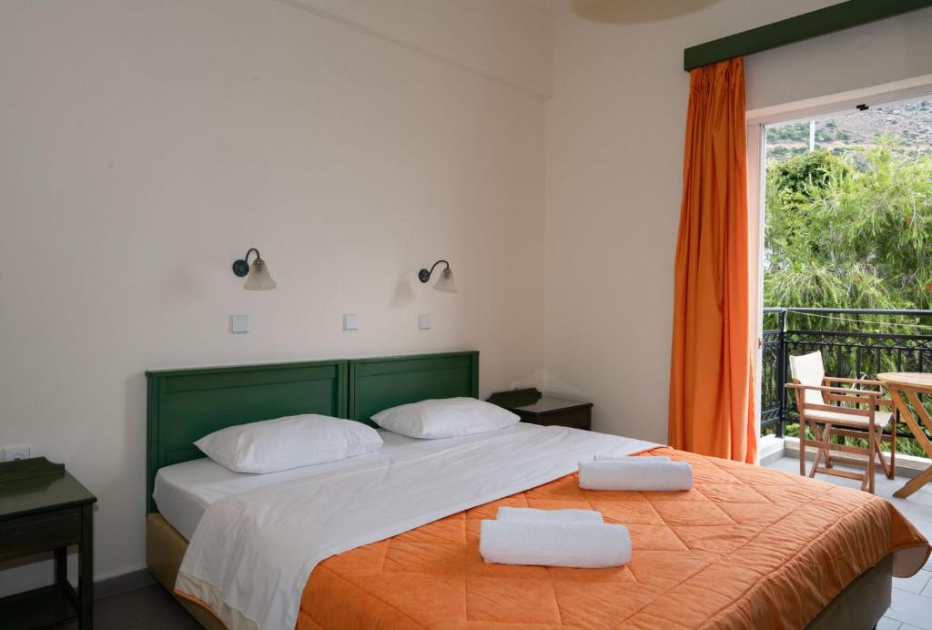 a bedroom with a bed with two towels on it at Aretousa in Sougia