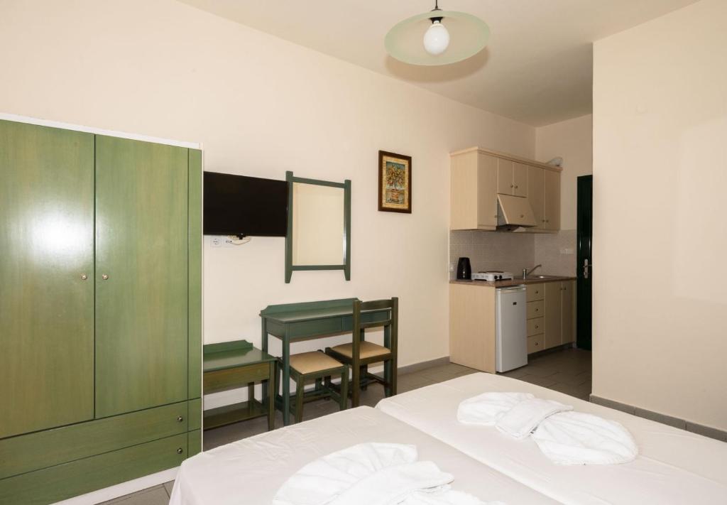 a bedroom with a bed and a table and a kitchen at Aretousa in Sougia