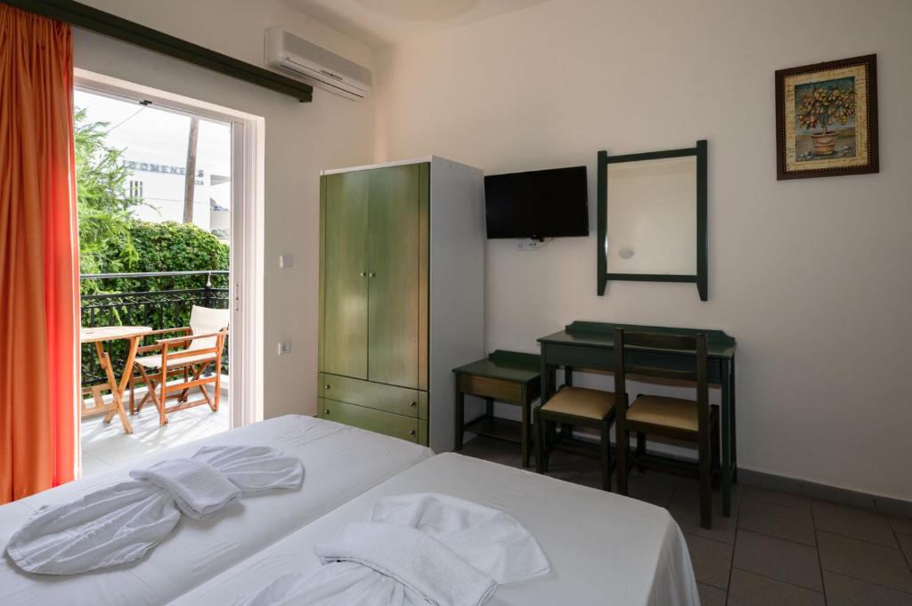 a bedroom with a bed and a table and a window at Aretousa in Sougia