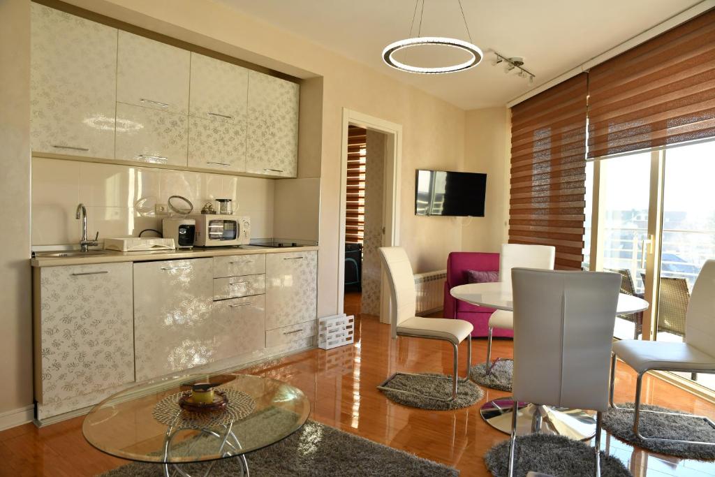 a kitchen and living room with a table and chairs at Apartman STUPOVI Zlatibor in Zlatibor