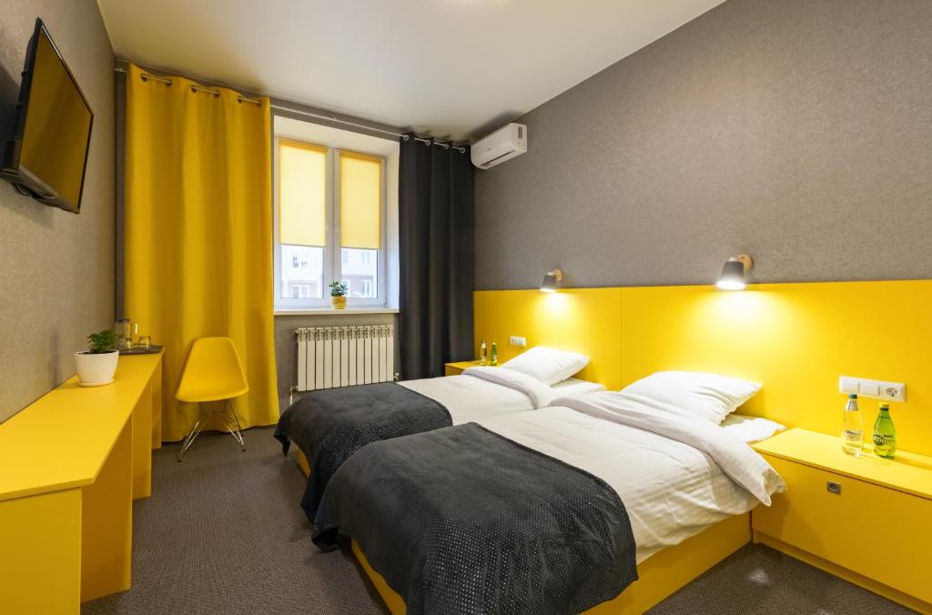 Отель Баларам في تولا: غرفة فندقية بسريرين و اللوح الأمامي اصفر
