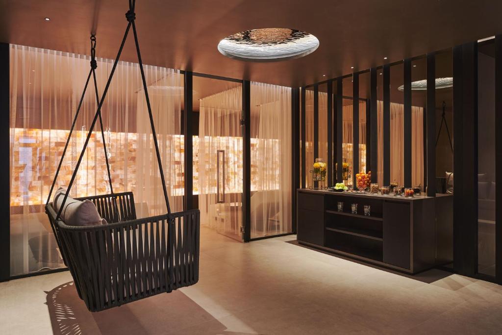 a swinging chair in a room with a bar at SCHLOSS Zermatt - CBD & Adaptogenic Spa and Sport Hotel in Zermatt