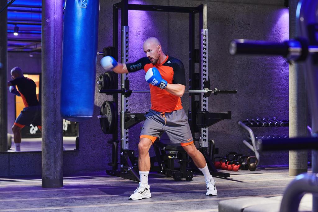 a man in a gym with a boxing glove at SCHLOSS Zermatt - CBD & Adaptogenic Spa and Sport Hotel in Zermatt