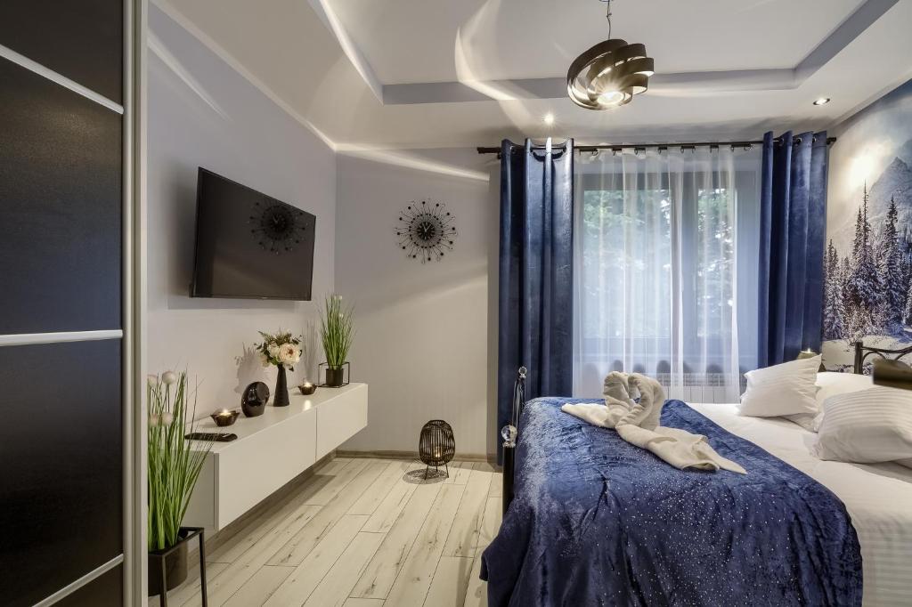 - une chambre avec un lit et une couverture bleue dans l'établissement Apartamenty u Romana, à Tylicz