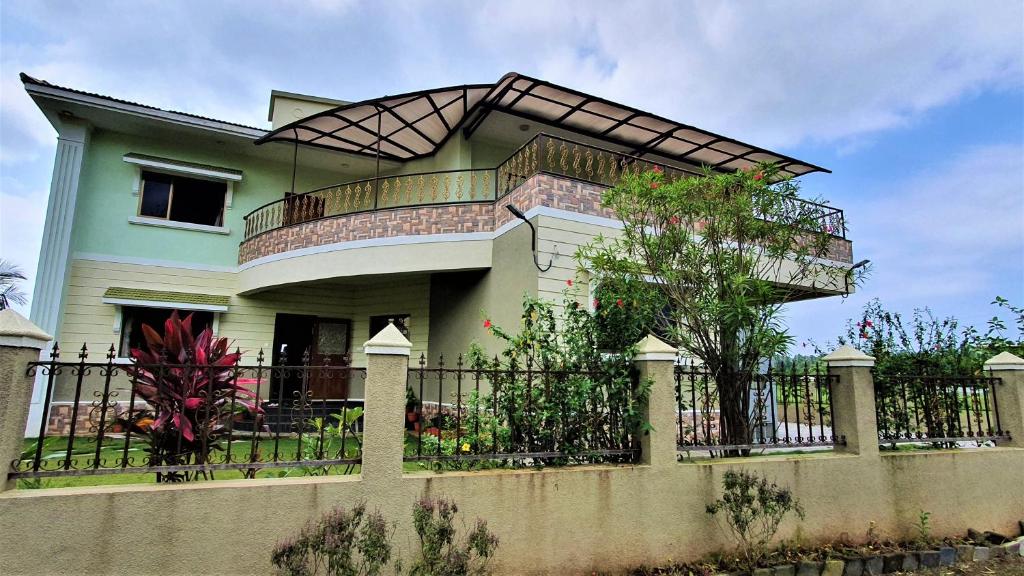 dom z balkonem na ogrodzeniu w obiekcie Nessies w mieście Alibag