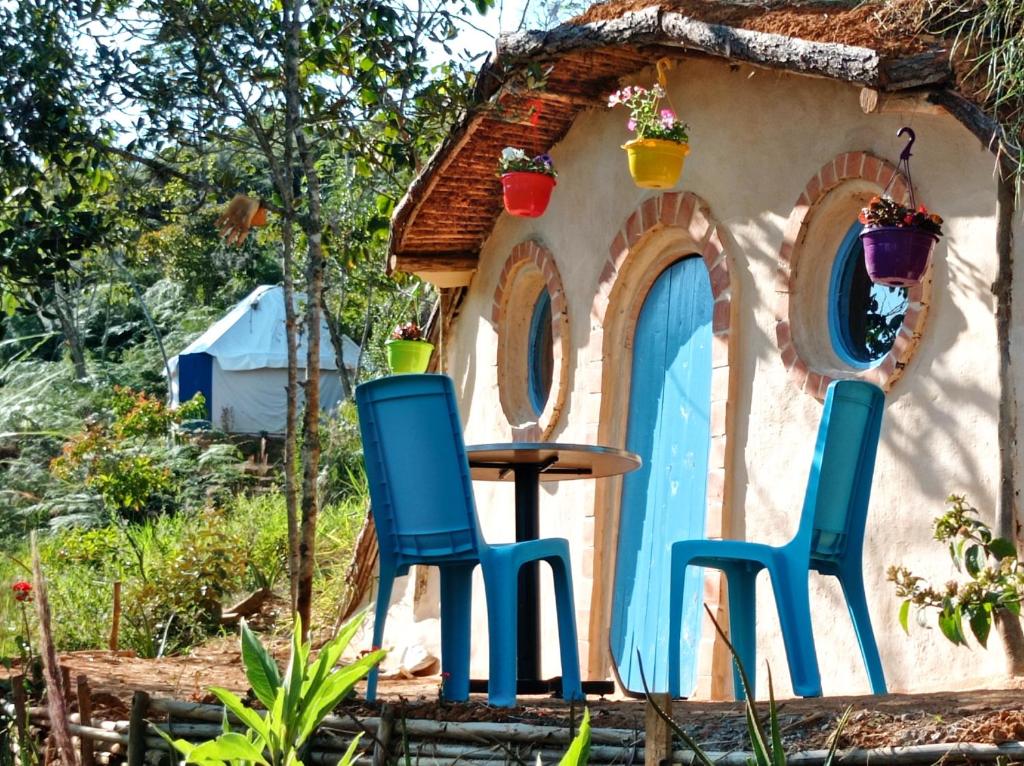 two chairs and a table in front of a small house at La Pacha Hostel in Barichara