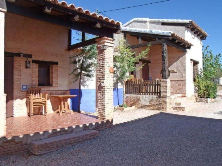 een huis met een patio en een tafel ervoor bij Casas rurales lagunas de Ruidera II in Ossa de Montiel