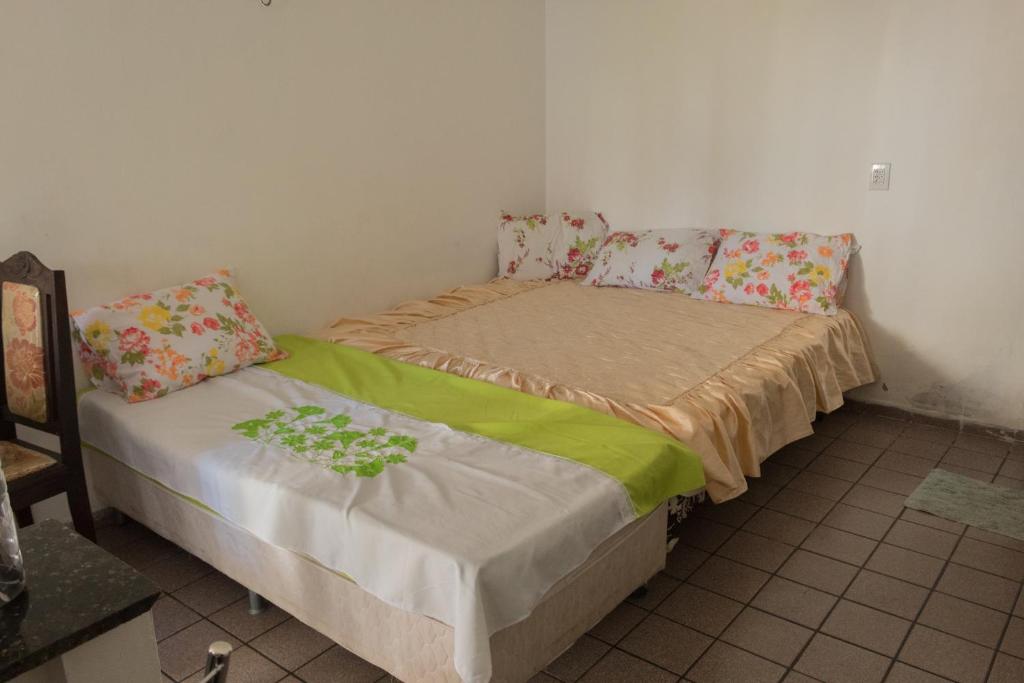 a small bedroom with a bed with green sheets at Ótima Suíte - Ponta Negra in Natal