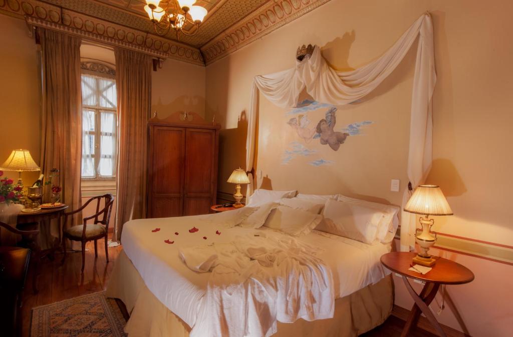 1 dormitorio con 1 cama blanca con dosel en Hotel Carvallo, en Cuenca