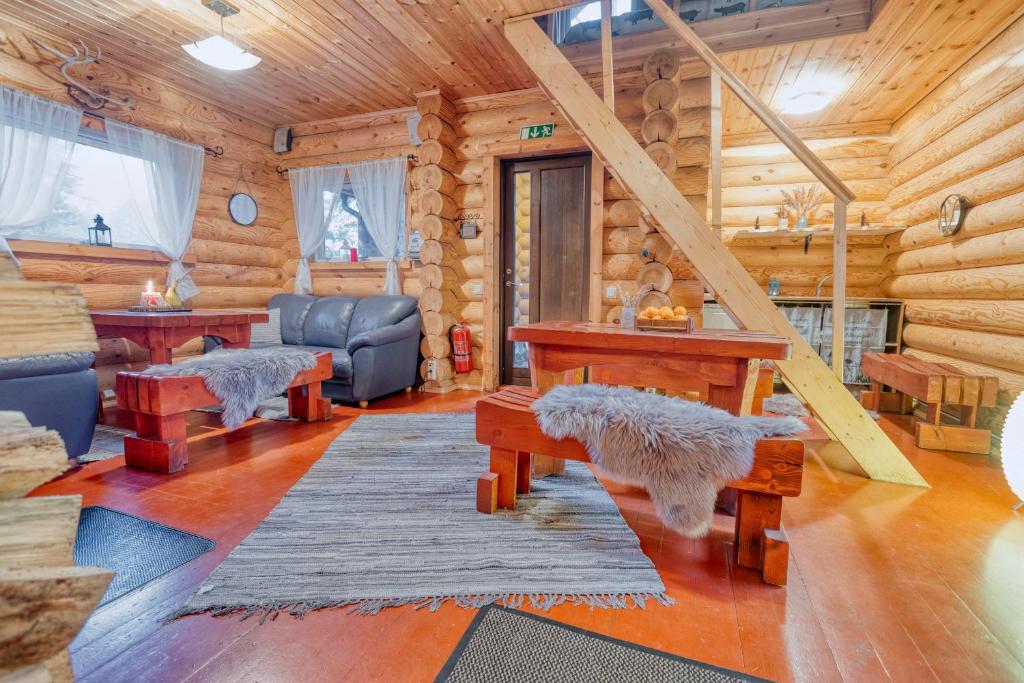 a living room with a staircase in a log cabin at Valkla Puhkekeskuse saunamaja in Kuusalu