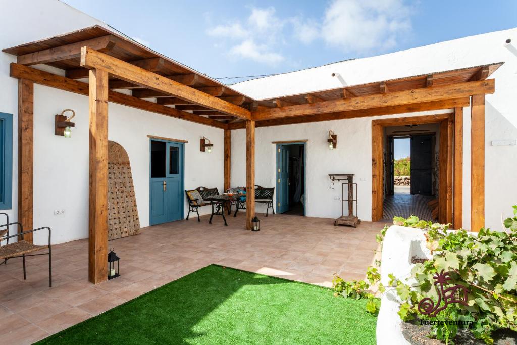 an outdoor patio with a wooden pergola at Casa Emblemática "Casa del Cuartel" in La Oliva