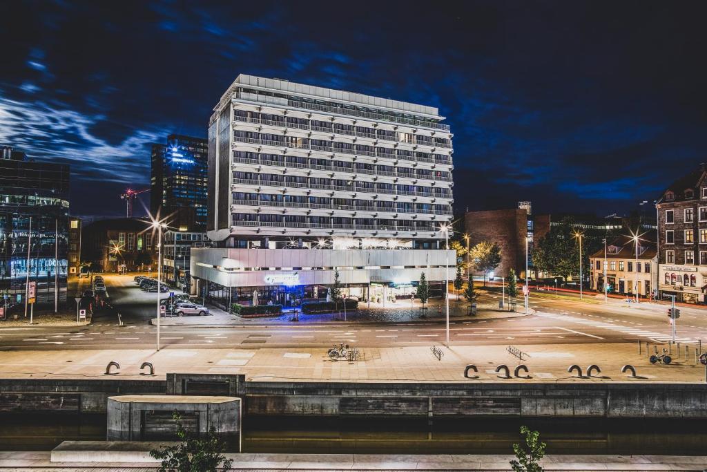 un grand bâtiment dans une ville la nuit dans l'établissement Hotel Atlantic, à Aarhus