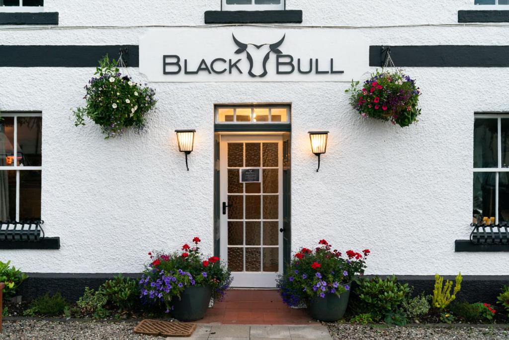 un edificio blanco con una señal de toro negro en él en Black Bull Gartmore, en Stirling