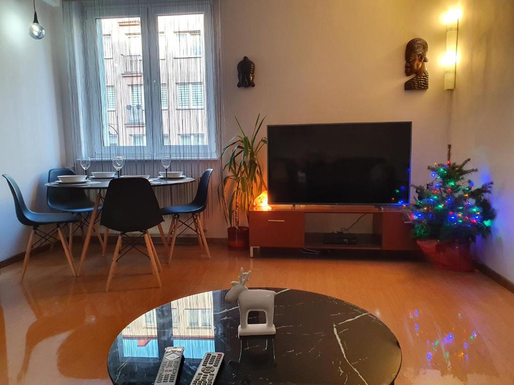 a living room with a television and a table with a christmas tree at Apartament komfortowy Levino in Lębork