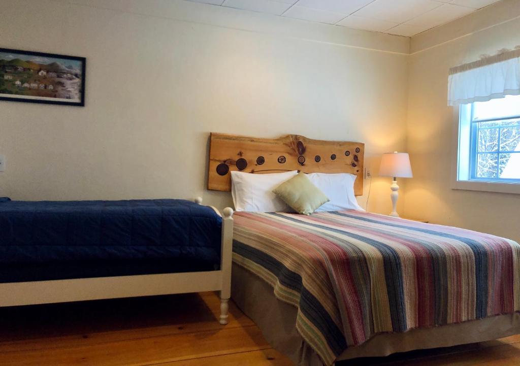 1 dormitorio con cama, ventana y cama sidx sidx sidx sidx en Trailside Inn, en Killington