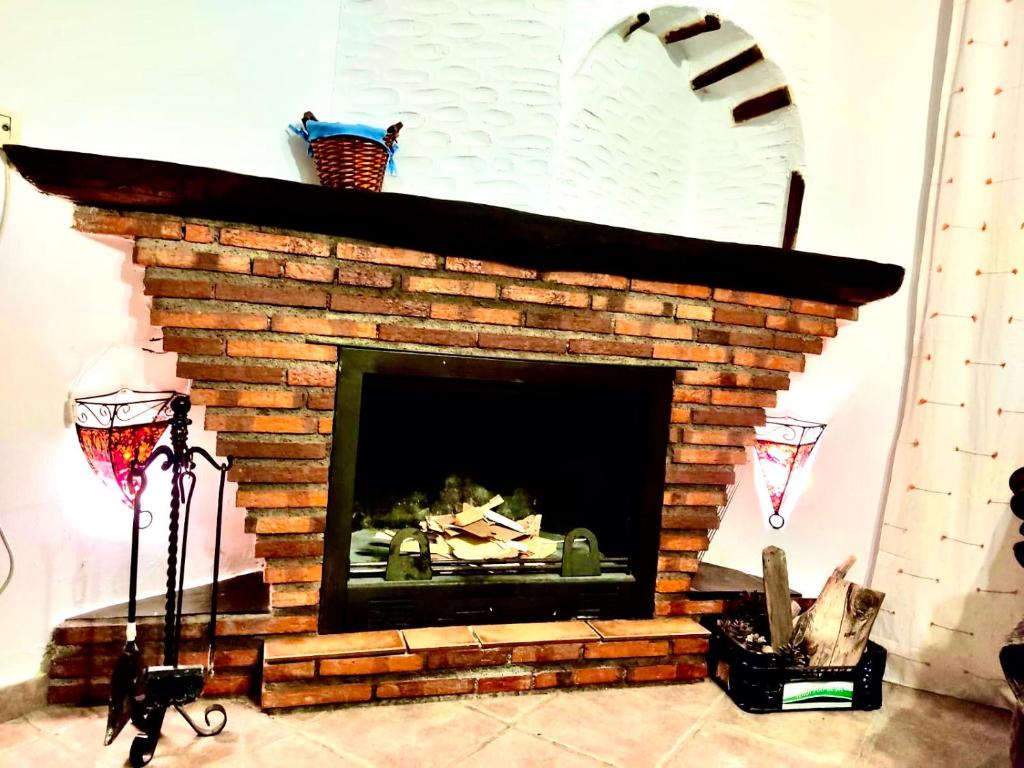 a brick fireplace in a living room at Casa en Busquistar in Busquístar