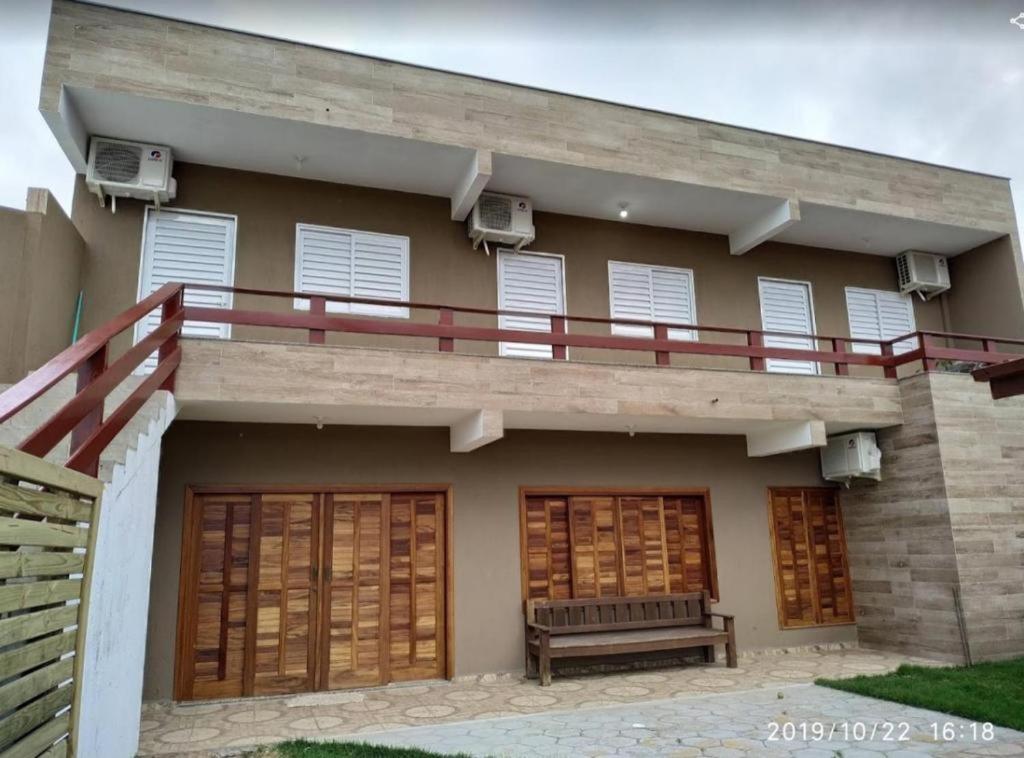 a house with a balcony with a bench on it at KITNET DO PESCADOR 3 in Imbituba