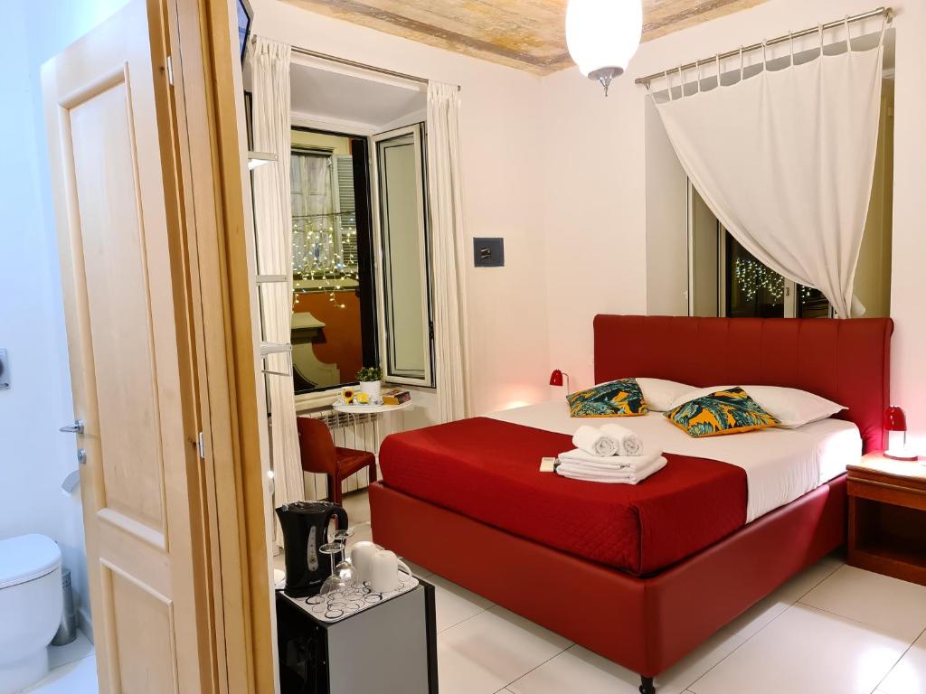 a bedroom with a red bed and a bathroom at I Dormienti in Rome