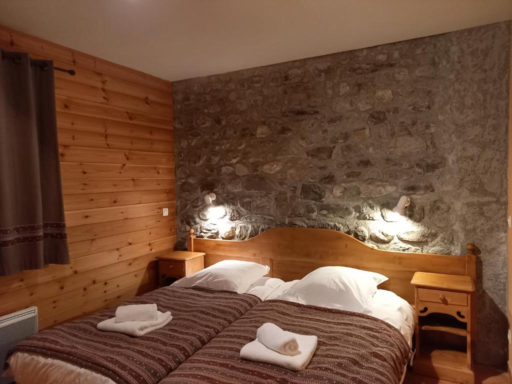 een slaapkamer met een bed met twee handdoeken erop bij La Voute apartments in La Grave