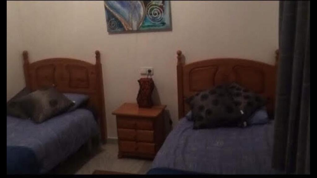 een slaapkamer met 2 bedden en een nachtkastje bij Villa delgado in La Marina de la Torre