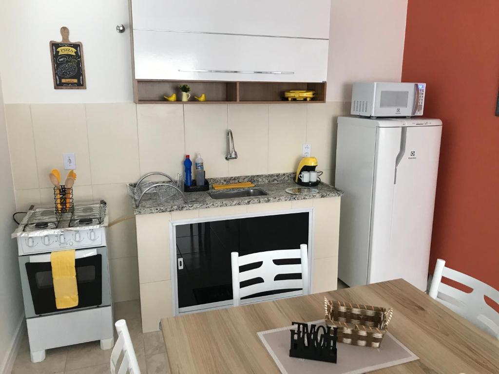 uma pequena cozinha com um fogão e um frigorífico em Apartamento Cantinho da Serra em Nova Friburgo