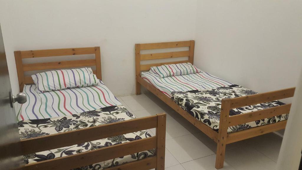 2 Betten nebeneinander in einem Zimmer in der Unterkunft HOMESTAY EIJAZ KUALA ROMPIN in Kuala Rompin