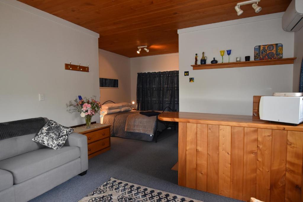 sala de estar con sofá y cama en Olivista en Masterton