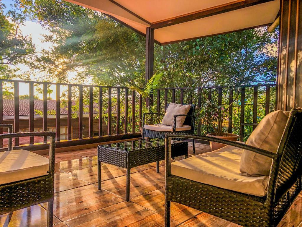 eine Veranda mit 2 Stühlen und einem Tisch auf einer Terrasse in der Unterkunft Montefresco Boutique Hostel in Monteverde Costa Rica