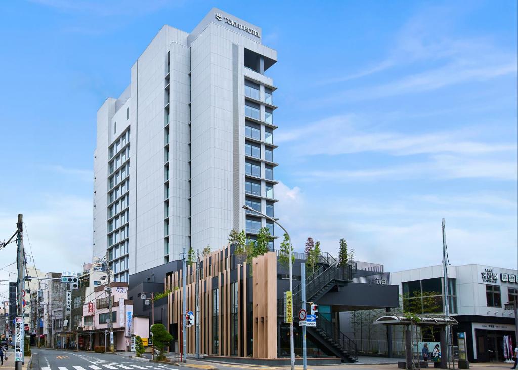 wysoki biały budynek przy ulicy miejskiej w obiekcie Fujisan Mishima Tokyu Hotel w mieście Mishima