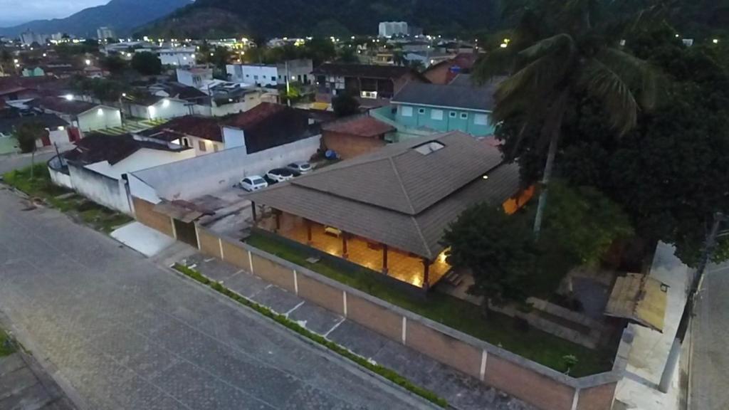ein Haus mit einem großen Dach in einer Stadt in der Unterkunft Suítes econômica Flor de Maria in Caraguatatuba