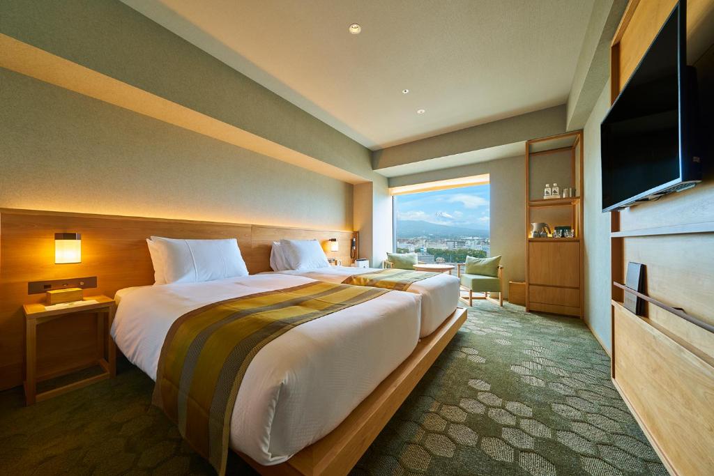 pokój hotelowy z dużym łóżkiem i dużym oknem w obiekcie Fujisan Mishima Tokyu Hotel w mieście Mishima