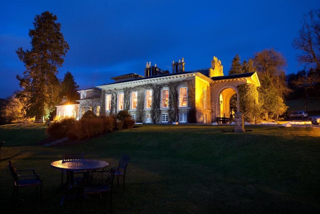 una casa grande con una mesa delante en Thainstone House, en Inverurie