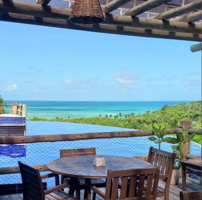 uma mesa com cadeiras e vista para o oceano em Villas do Pratagy CocoBambu em Maceió