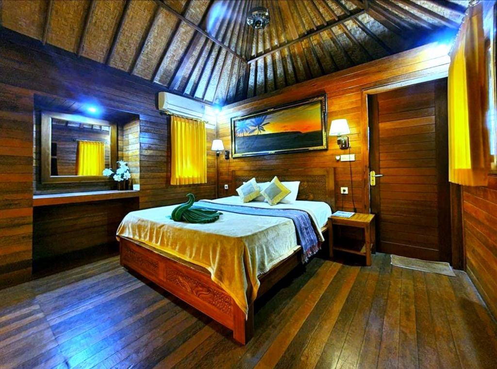 a bedroom with a bed in a wooden room at Lembongan Tropical Guesthouse in Nusa Lembongan