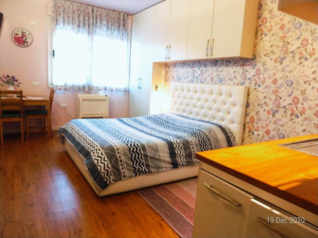 1 dormitorio con 1 cama y cocina con mesa en Studio Silva, en Tirana