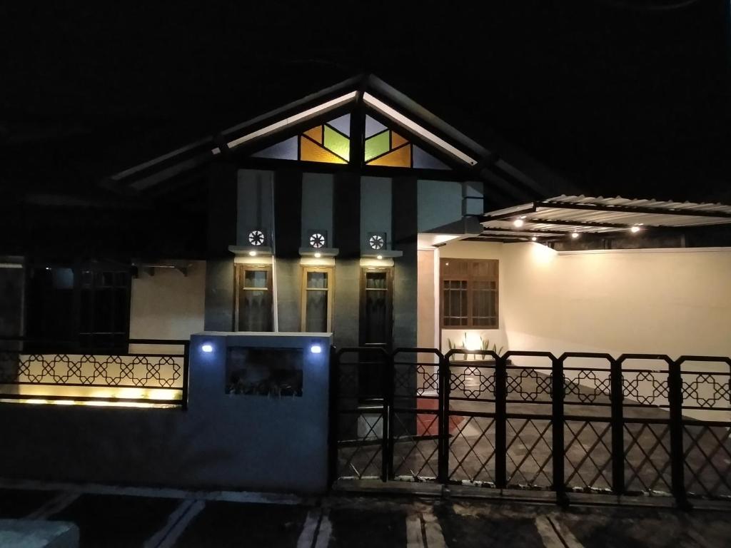 una casa iluminada por la noche con una ventana en Abadi Homestay en Yogyakarta