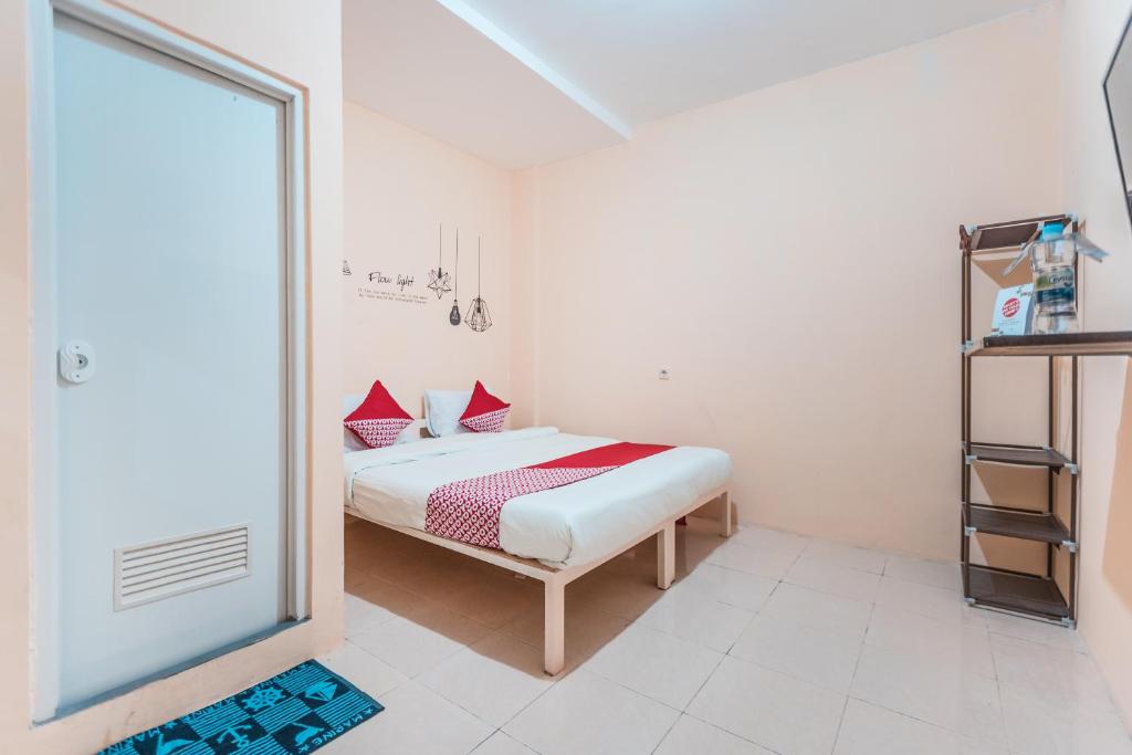 um quarto com uma cama com almofadas vermelhas em Super OYO 2034 Eden Guest House em Depok