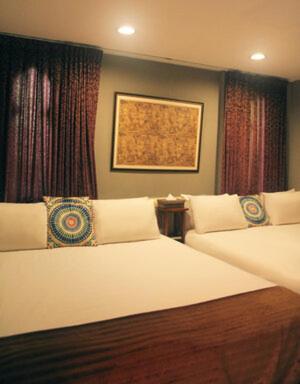 a bedroom with two beds and a painting on the wall at Raid Garden Boutique Hotel in Magong