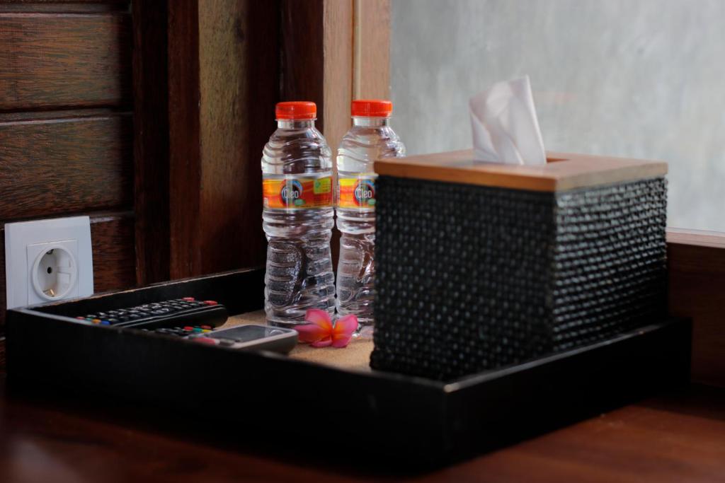 two bottles of water sitting next to a remote control at Bingin Lodge Uluwatu in Uluwatu