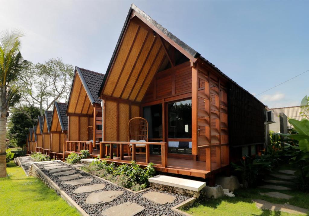 a wooden house with a porch and a patio at Bingin Lodge Uluwatu in Uluwatu