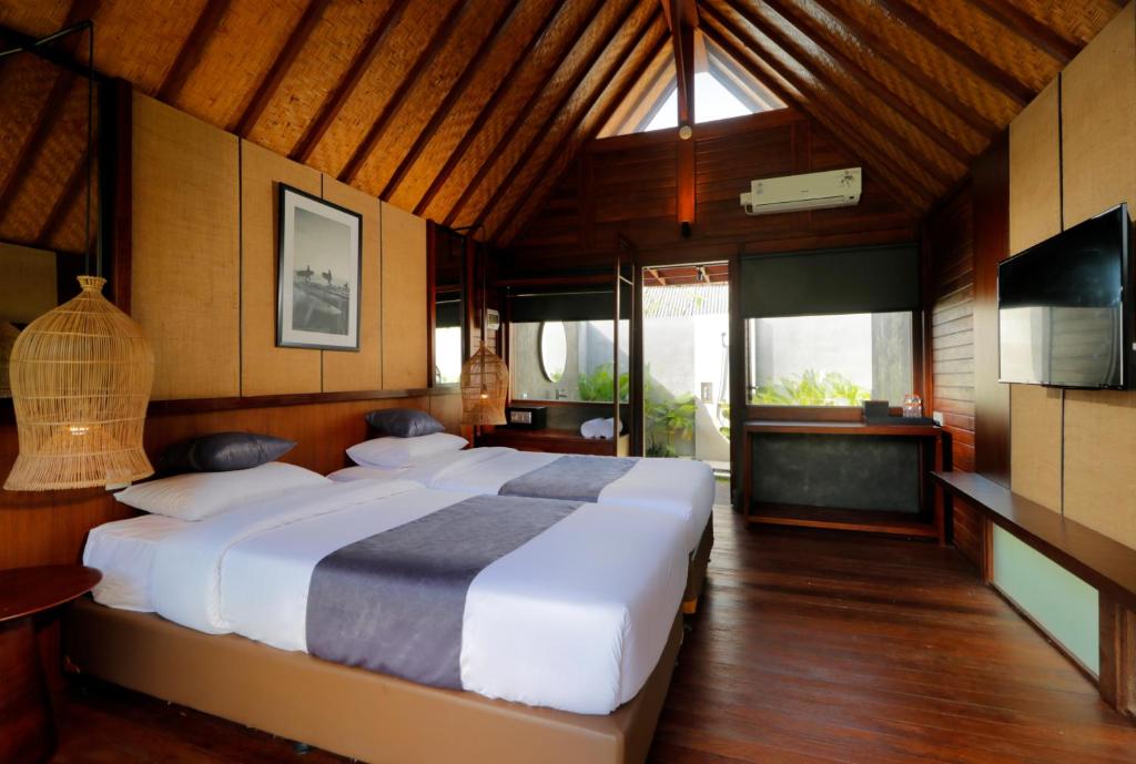 a bedroom with a large bed in a room at Bingin Lodge Uluwatu in Uluwatu
