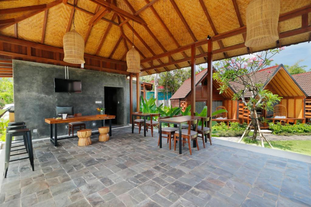 an outdoor patio with a table and chairs at Bingin Lodge Uluwatu in Uluwatu