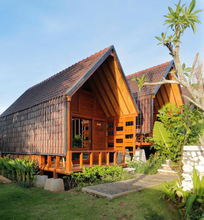 a wooden house with a gambrel roof at Bingin Lodge Uluwatu in Uluwatu