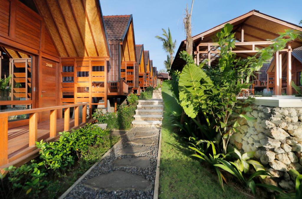 a row of wooden houses with a path between them at Bingin Lodge Uluwatu in Uluwatu