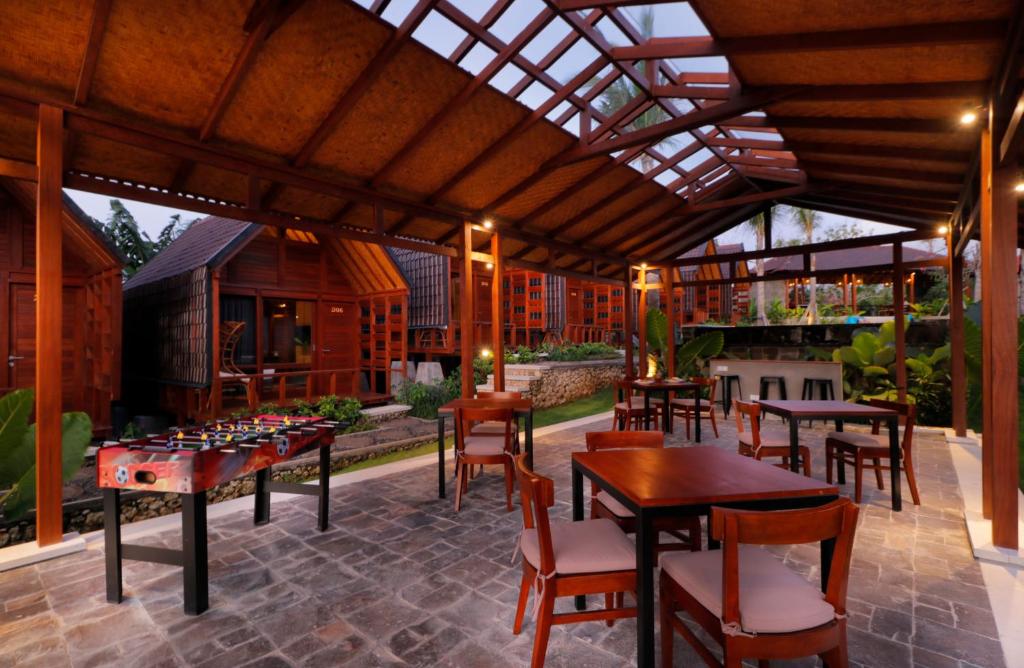 an outdoor patio with tables and chairs and a chessboard at Bingin Lodge Uluwatu in Uluwatu