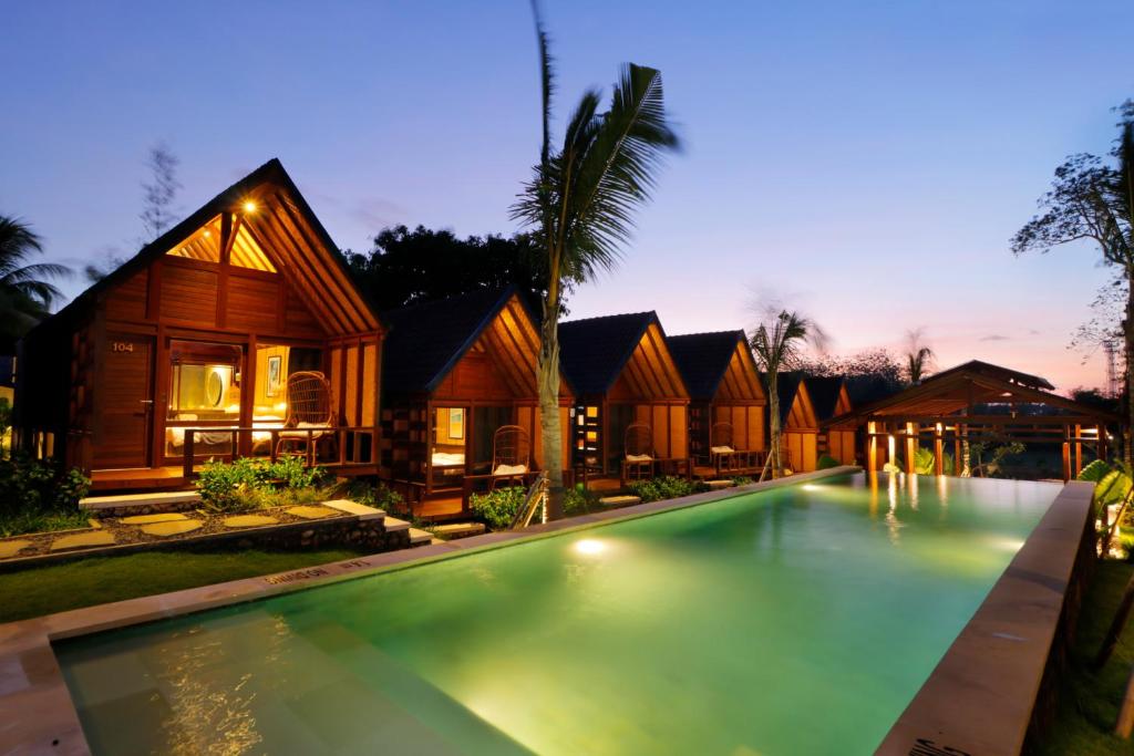 a villa with a swimming pool at night at Bingin Lodge Uluwatu in Uluwatu