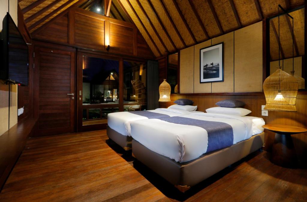 a bedroom with two large beds in a room at Bingin Lodge Uluwatu in Uluwatu