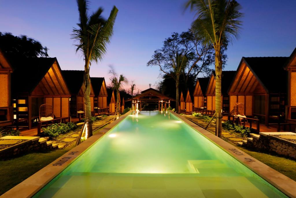 a swimming pool in a resort at night at Bingin Lodge Uluwatu in Uluwatu