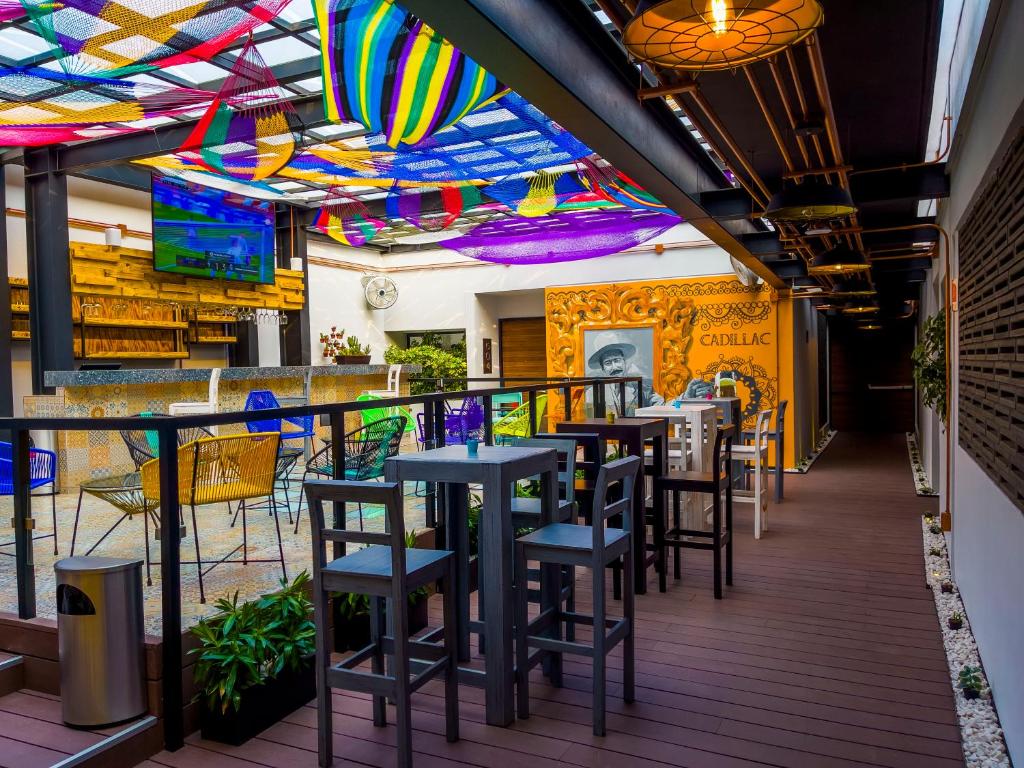 a restaurant with tables and chairs and a colorful ceiling at Cadillac Hotel Boutique in Mexico City