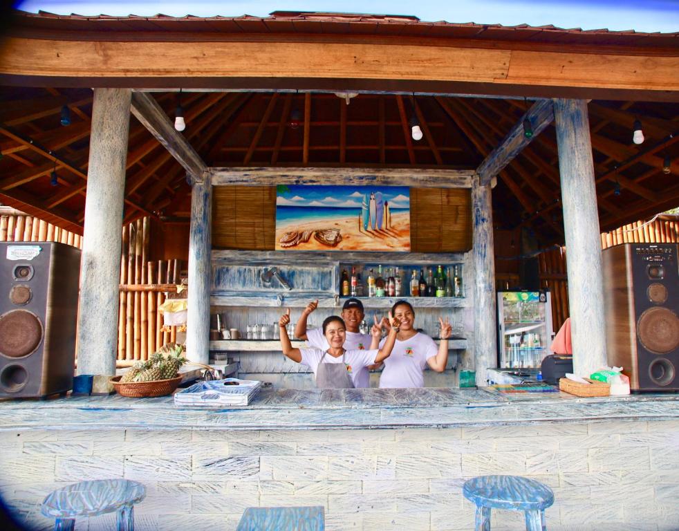 een groep van drie personen die in een bar staan bij The Palms Ceningan Hotel in Nusa Lembongan